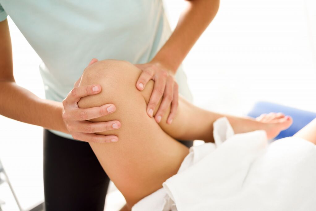 Der Spezialist macht die therapeutische Massage mit Arthrose des Knies